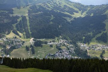 Looking down in valley with Les Gets outdoor sports holiday destination surrounded by the green French Alps seen from the Belvedere mountain