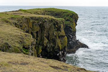 Waves washing against black basalt cliffs at Arnarstapi Cliffs in Snaefellsnes Peninsula, Iceland