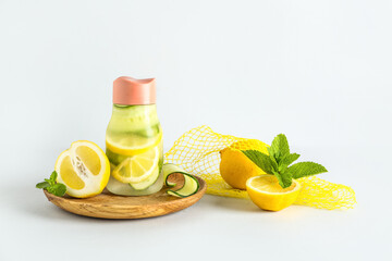 Sports bottle of lemonade with cucumber and mint on white background