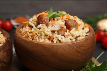 Delicious pilaf with meat and carrot in bowl on table, closeup