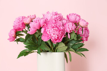 Vase of pink peonies on color background
