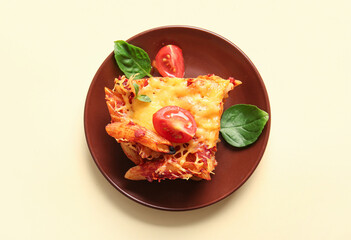 Plate of pasta with tomato sauce and cheese on beige background