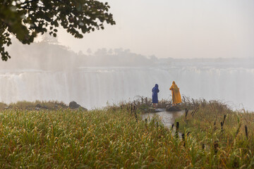 Victoria Falls Waterfall Rainforset with tourist in raincoat