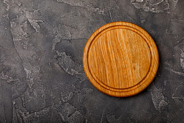 Cutting board on a textured table. Pizza board. Kitchen wooden cutting board and kitchen towel. Kitchenware. Menu. Recipe. The concept of cooking. Mockup