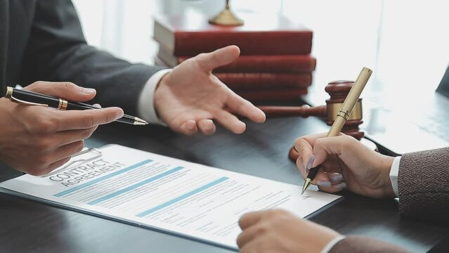 Business and lawyers discussing contract papers with brass scale on desk in office. Law, legal services, advice, justice and law concept picture with film grain effect
