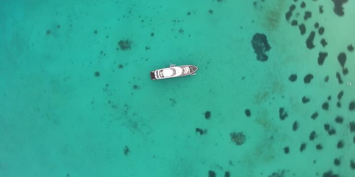 White yacht in the ocean against a backdrop of caral reefs in Egypt. Aerial shot over the boat