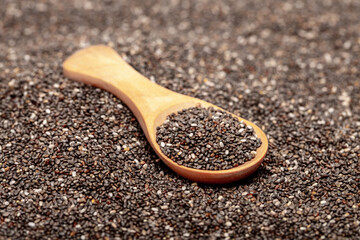 Chia seeds close-up with a wooden spoon. Chia seeds macro. Dry healthy supplement for proper nutrition.