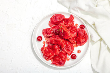 Dumplings, filled fresh cherries. Ripe fruits, sweet sauce, sour cream. Traditional Ukrainian dish