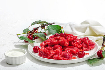 Dumplings, filled fresh cherries. Ripe fruits, sweet sauce, sour cream. Traditional Ukrainian dish