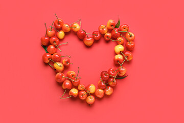 Heart made of sweet cherries on red background