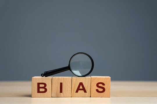 Bias word on a wooden blocks. Prejudice. Personal opinions. Preconception. Concept of facts and biases. Magnifying glass
