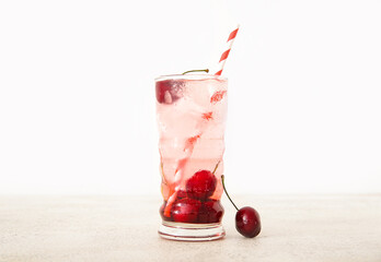 Glass of tasty cherry lemonade on white background