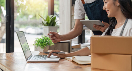 Asian Couple lover checking order and prepare parcel for customers at home, seller online concept