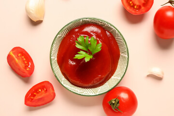 Bowl with tomato paste and fresh vegetables on light background