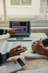Two company executives working together closely Two Asian businessmen work together to review business in the office.