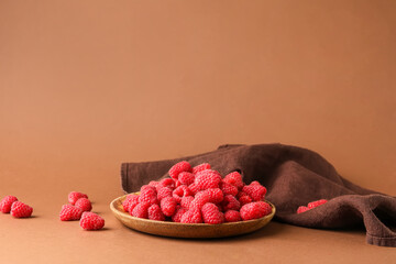 Plate with fresh raspberries on brown background © Pixel-Shot