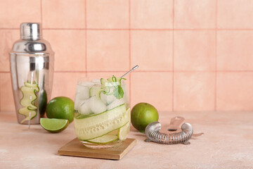 Glass of mojito with cucumber on pink grunge table