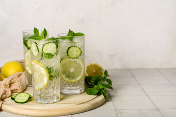 Glasses of mojito with cucumber on tile table