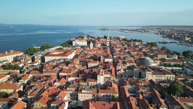 Zadar old town peninsula glowing on morning sun. Drone footage, slide over rooftops. Croatia summer