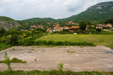 Abandoned rural basketball and soccer fields at the foot of the mountain.