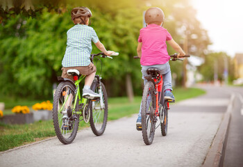 Fototapeta premium Two boys riding on their bicycles along an asphalt road