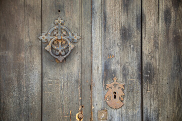 Detail of old dark wooden door with metal knocker and lock