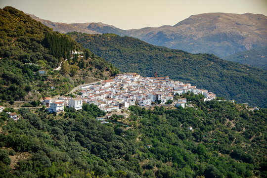 View in the distance of the white village of Algatocin, in the province of Malaga and between green mountains of the Serrania de Ronda