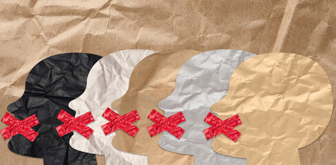 Cutout figures of heads with taped mouths on brown crumpled paper background, lack of freedom of...