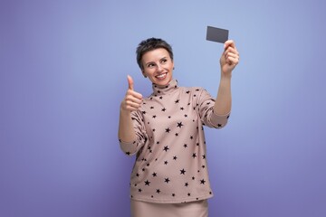 pretty young gray-haired european woman dressed in a blouse and skirt holding a plastic card mockup