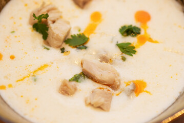 Tom Kha soup with coconut milk with chicken and herbs, closeup, Thai cuisine.