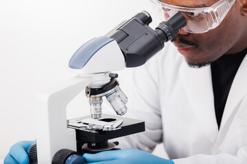 african american scientist in lab working with microscope