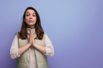 young brunette female adult in casual attire folded her hands for prayer and supplication