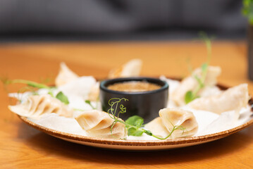 Gyoza or Japanese fried dumplings with sauce in a plate in a Asian restaurant.