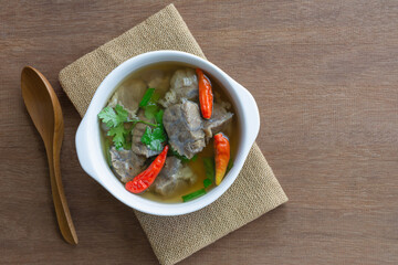 top view of spicy tender boiled beef soup in a ceramic bowl on wooden table. asian homemade style food concept.