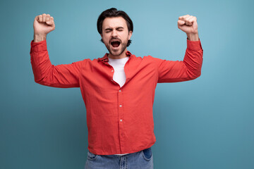 Naklejka premium young strong handsome guy with black hair shows strength and confidence
