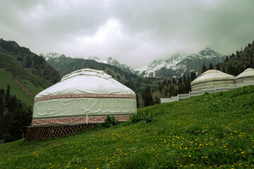 Kazakh guest yurt on the background of mountains not far from Almaty in early autumn. A beautiful landscape with a traditional nomad house in the mountains of Almaty.