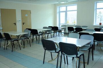 Empty hospital canteen, table chairs doors windows, interior