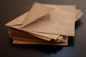 Brown craft envelope isolated on black background. Top view. stack of old envelopes