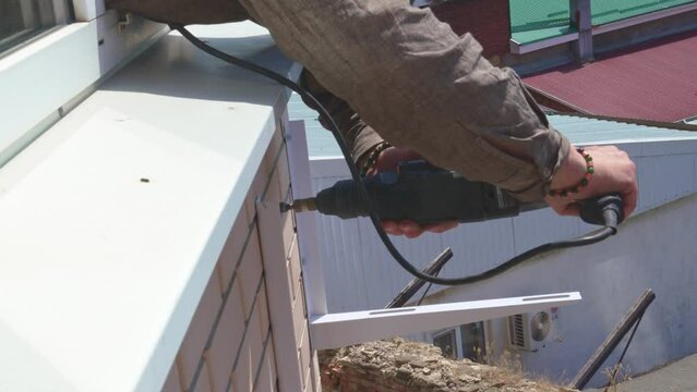 Drilling wall of the house for fastening the outdoor unit of the split system.