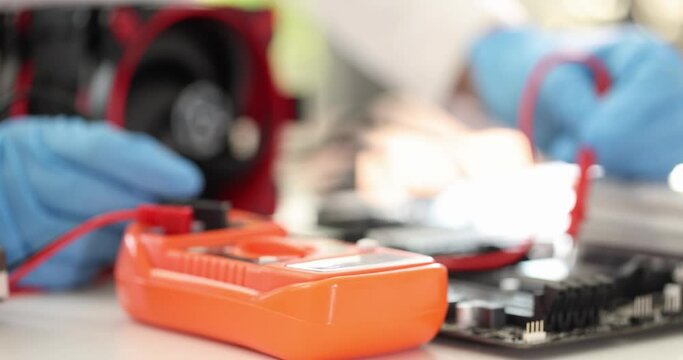 Multimeter tester lying on table in computer workshop 4k movie slow motion. Repair of computer equipment concept
