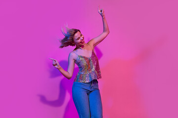 Photo of excited active lady enjoy weekend friday party moving dancing isolated on colorful neon background