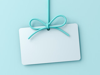Blank gift card or hanging white note with blue cyan rope bow isolated on blue pastel color wall background with shadow minimal conceptual 3D rendering
