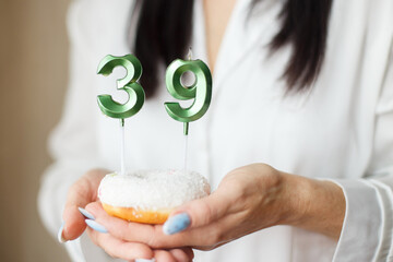 woman holding a cake with the number 39 candles