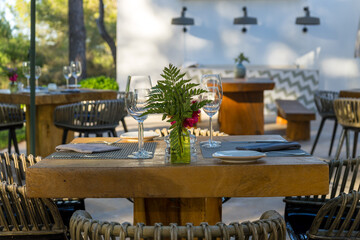 Fototapeta na wymiar Sunset table for two set for dinner at Mediterranean restaurant. Romantic holiday. Honeymooners.