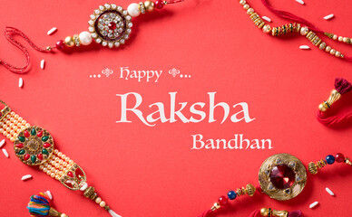 Fototapeta na wymiar Raksha Bandhan, Indian festival with beautiful Rakhi and Rice Grains on red background. A traditional Indian wrist band which is a symbol of love between Sisters and Brothers.