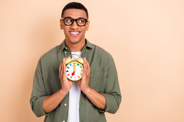 Portrait of intelligent handsome positive man wear glasses stylish shirt hold alarm look empty...
