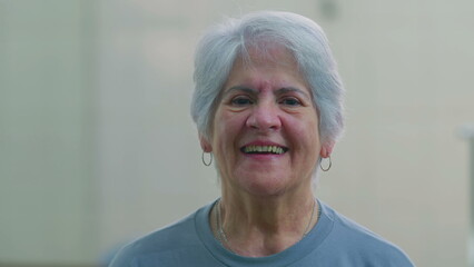 Happy senior woman close-up face smiling and laughing. Casual caucasian older female person in 70s