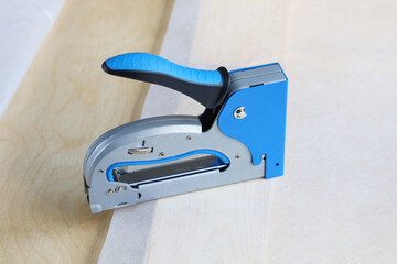 construction stapler is on surface of material, close-up