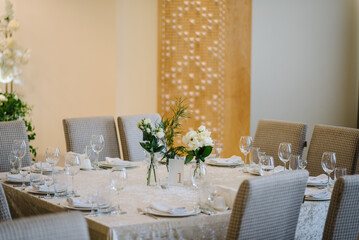 Served banquet tables ready for guests, table with plate, glasses, forks, napkins. Table number 1. Stands, sign number one. Luxury reception. Elegant table decorated composition flowers in party area