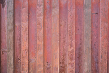 Wall of a sea container with traces of rust on the red paint.